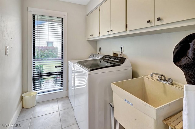 laundry room with sink, light tile patterned floors, washer and clothes dryer, and cabinets