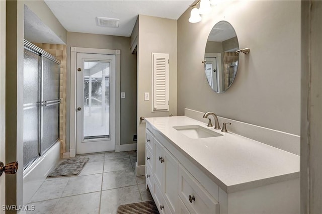 bathroom featuring tile patterned flooring, vanity, and shower / bath combination with glass door