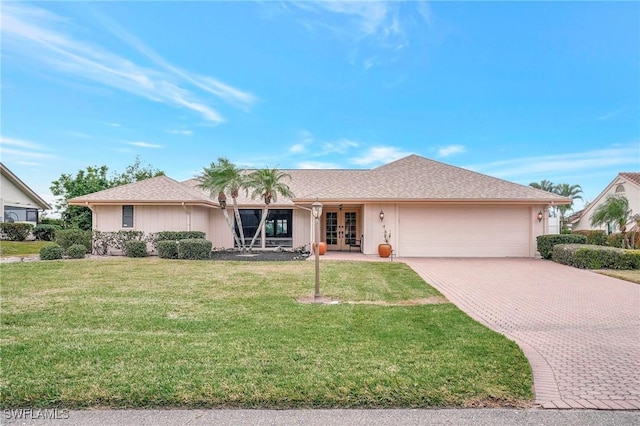 single story home featuring a garage, a front yard, and french doors