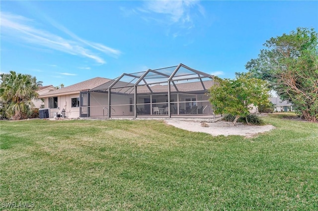 rear view of house featuring cooling unit, a yard, and glass enclosure