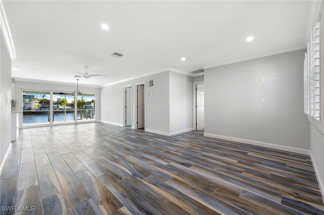 spare room featuring dark wood-type flooring, a water view, ornamental molding, and ceiling fan