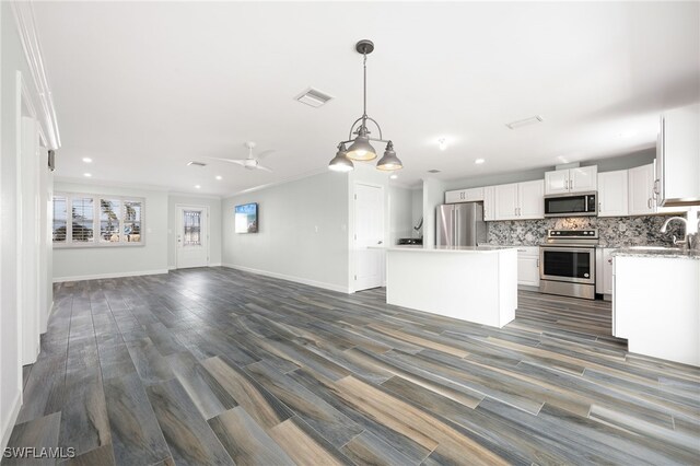 kitchen featuring white cabinetry, tasteful backsplash, a center island, hanging light fixtures, and stainless steel appliances