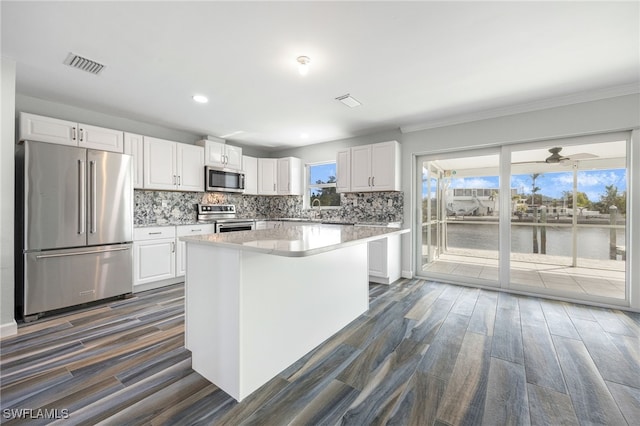 kitchen featuring white cabinetry, a healthy amount of sunlight, appliances with stainless steel finishes, and a center island