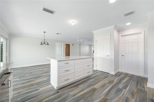 kitchen featuring a center island, dark hardwood / wood-style flooring, decorative light fixtures, and white cabinets