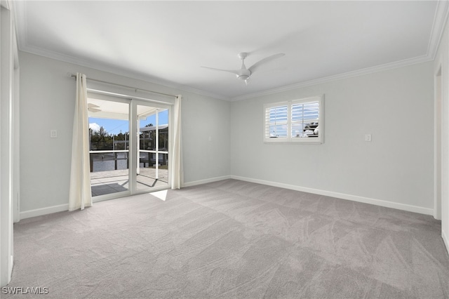 unfurnished room featuring a wealth of natural light, light colored carpet, ceiling fan, and crown molding