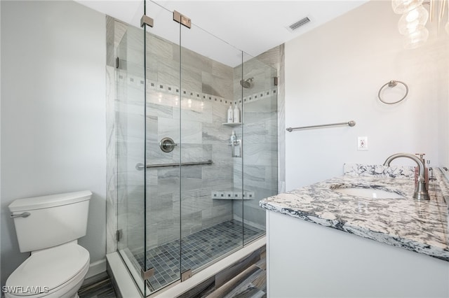 bathroom featuring vanity, toilet, and an enclosed shower