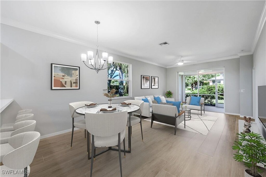 dining room featuring ornamental molding, light hardwood / wood-style flooring, and ceiling fan with notable chandelier