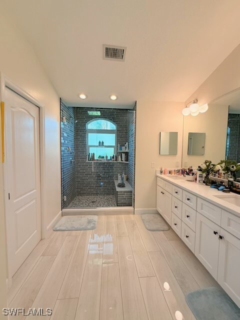 bathroom with walk in shower and vanity