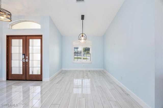 entryway with baseboards, visible vents, vaulted ceiling, light wood-style floors, and french doors