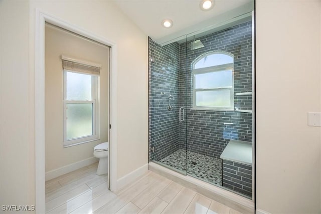 bathroom featuring wood tiled floor, baseboards, recessed lighting, toilet, and a shower stall