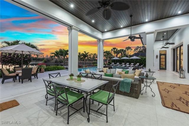 patio terrace at dusk with ceiling fan and an outdoor hangout area