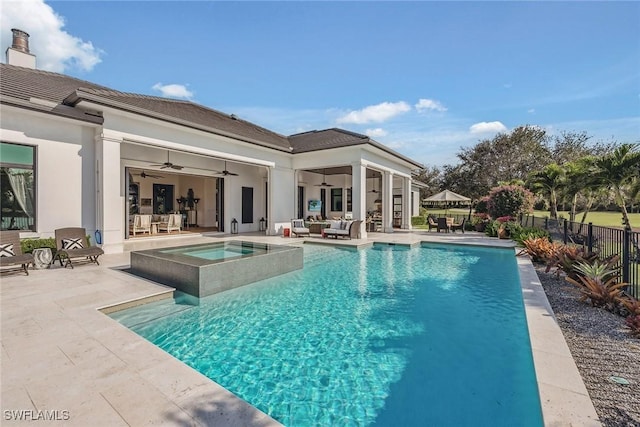 view of swimming pool with an in ground hot tub, a patio area, ceiling fan, and an outdoor living space