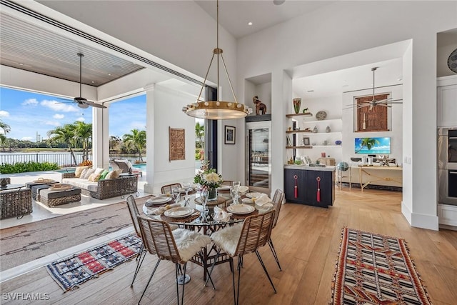 dining room with ceiling fan, built in features, and light wood-type flooring