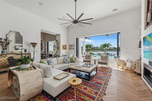 living room featuring a towering ceiling and light parquet flooring