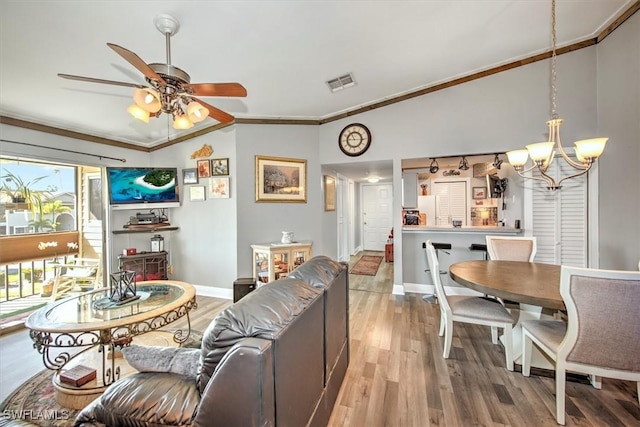 living room featuring ceiling fan with notable chandelier, light wood-type flooring, and crown molding