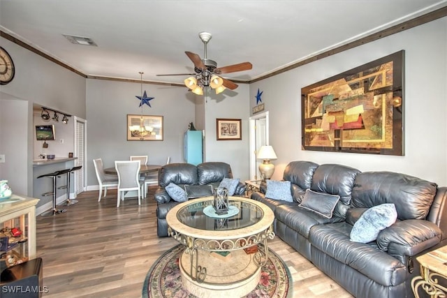 living room featuring hardwood / wood-style flooring, ceiling fan, and crown molding