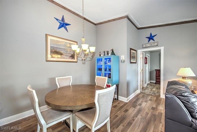 dining room with a chandelier, dark hardwood / wood-style flooring, and crown molding