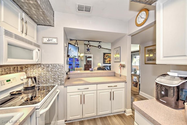 kitchen featuring decorative backsplash, white appliances, light hardwood / wood-style floors, and white cabinetry