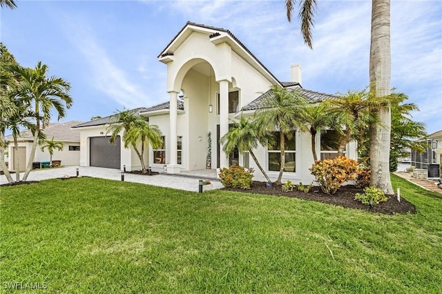 mediterranean / spanish house featuring a garage and a front lawn