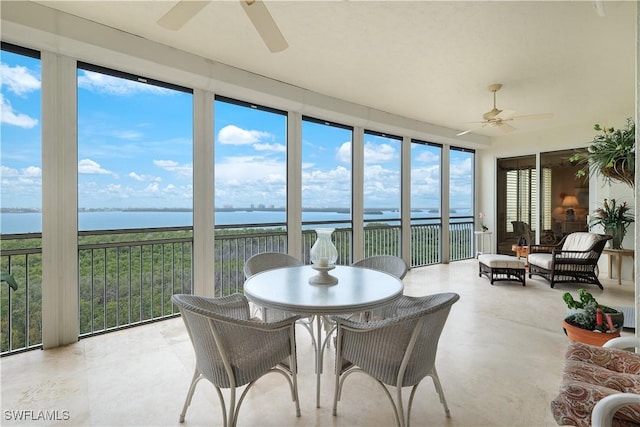 sunroom / solarium featuring a water view and ceiling fan