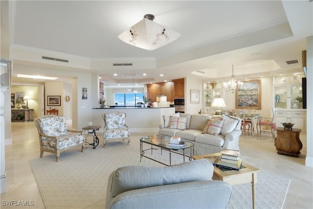 living room featuring crown molding, a tray ceiling, and a notable chandelier