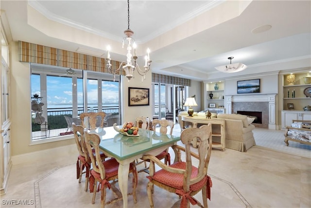 dining area with crown molding, a raised ceiling, built in shelves, and a notable chandelier