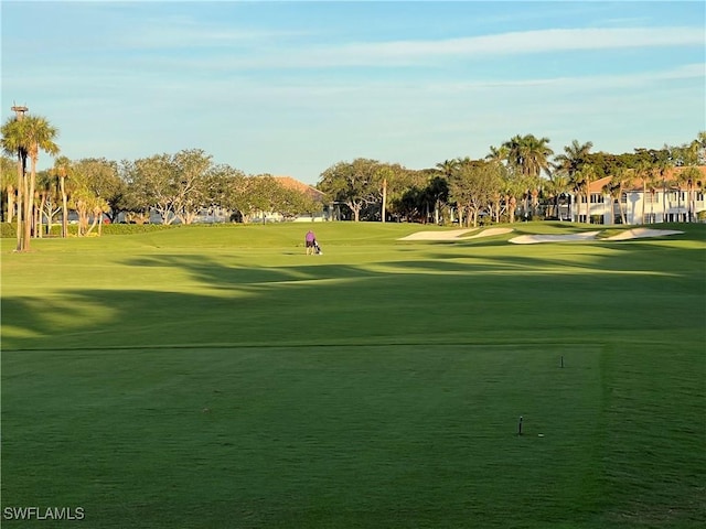 view of home's community featuring view of golf course and a lawn