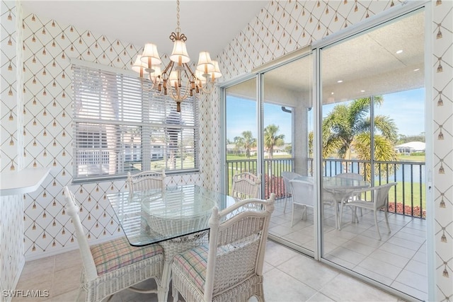 tiled dining room with a chandelier and wallpapered walls