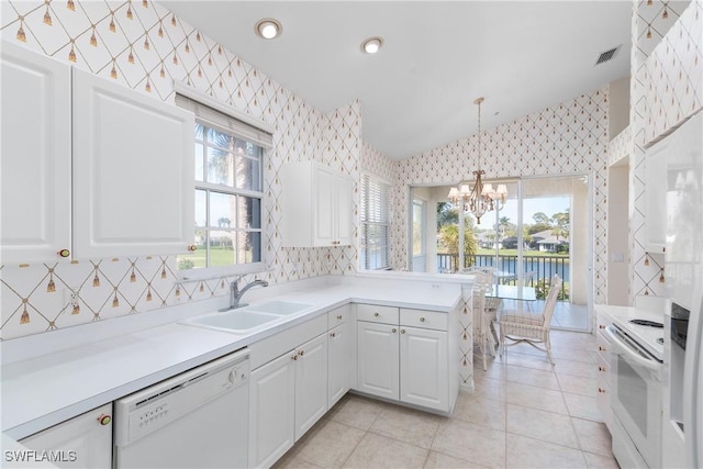 kitchen with white appliances, a sink, white cabinetry, visible vents, and wallpapered walls