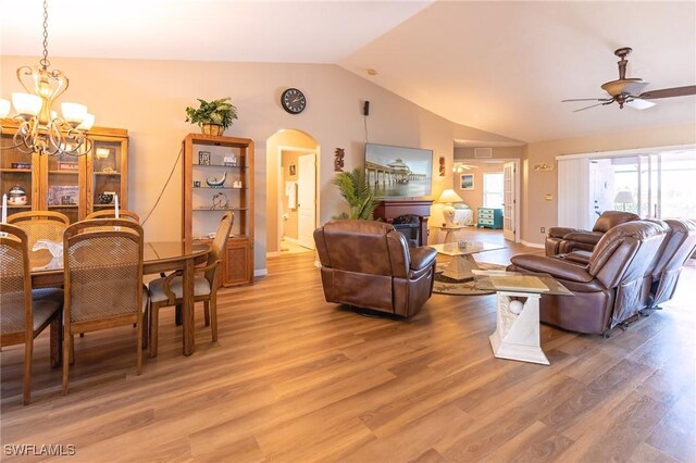 living room with hardwood / wood-style flooring, ceiling fan with notable chandelier, and lofted ceiling