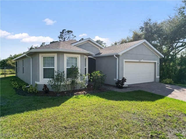 single story home with an attached garage, a front yard, and stucco siding