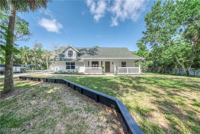 view of front facade featuring a porch, a front yard, and fence