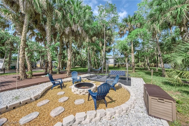 view of home's community with an outdoor fire pit and a lawn