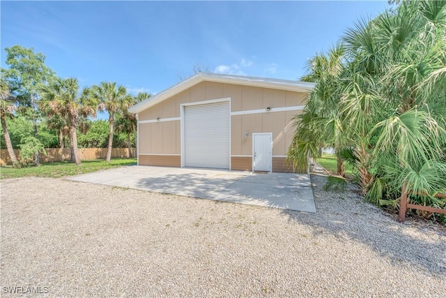 detached garage with fence and concrete driveway