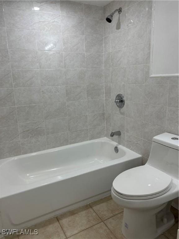 bathroom with tile patterned floors, toilet, and tiled shower / bath