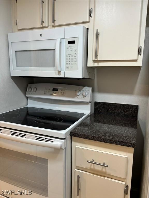 kitchen featuring white cabinetry and white appliances