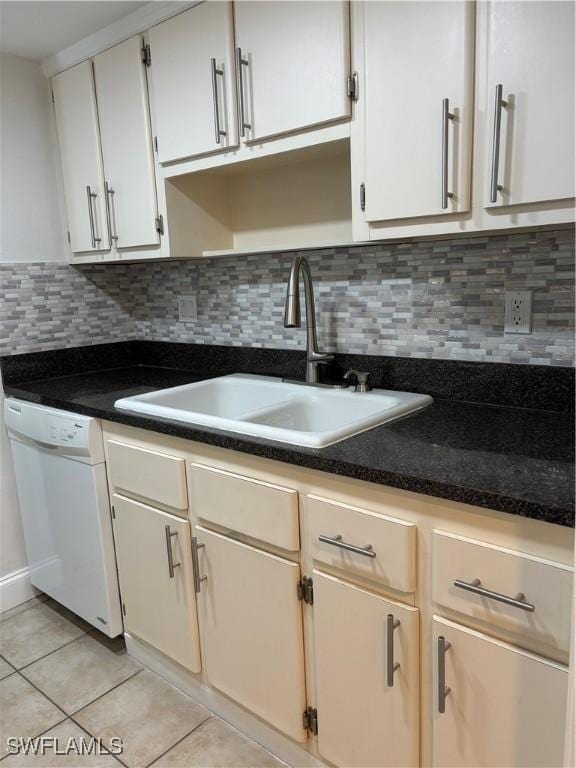 kitchen featuring white dishwasher, white cabinetry, sink, and tasteful backsplash