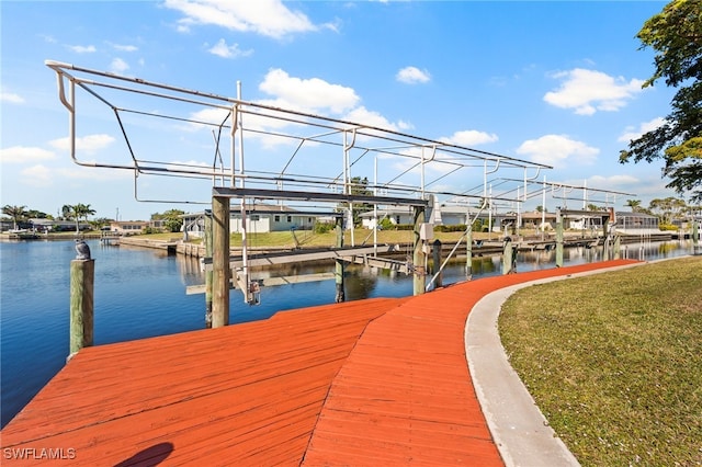 view of dock with a yard and a water view