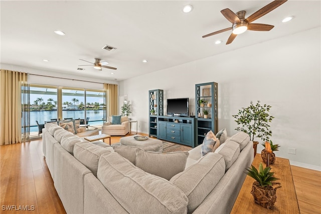 living room with light hardwood / wood-style floors and ceiling fan