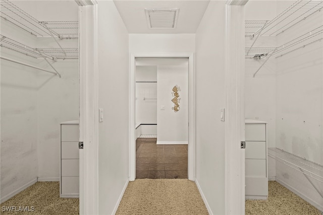 walk in closet featuring light colored carpet