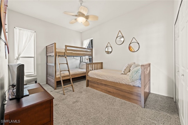 carpeted bedroom featuring ceiling fan and a closet