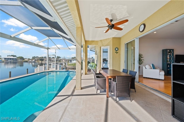 view of swimming pool featuring a water view, a patio area, ceiling fan, and a lanai