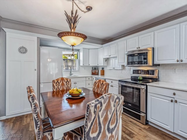 kitchen with white cabinets, pendant lighting, stainless steel appliances, and sink