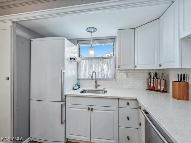 kitchen featuring white cabinets, decorative light fixtures, and white refrigerator