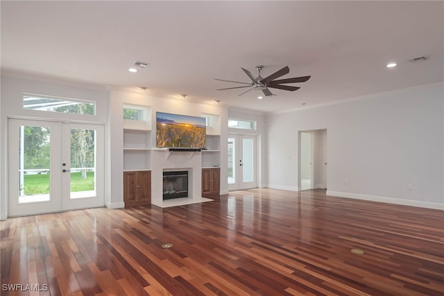 unfurnished living room with ceiling fan, dark hardwood / wood-style flooring, built in features, and french doors