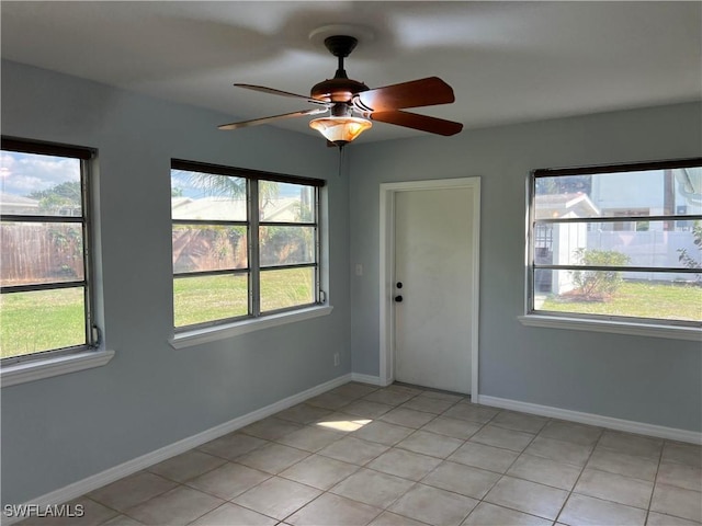 tiled empty room with plenty of natural light and ceiling fan