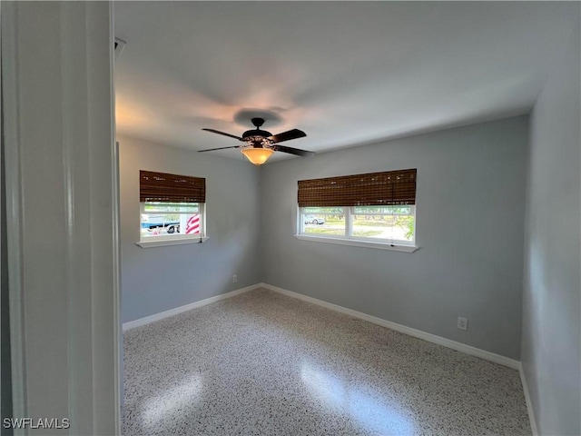 unfurnished room featuring a wealth of natural light and ceiling fan