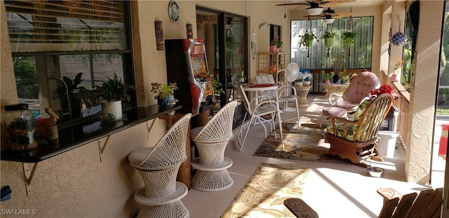 sunroom / solarium featuring ceiling fan