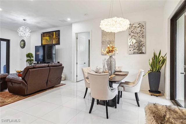 tiled dining room featuring an inviting chandelier