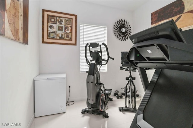 exercise room with light tile patterned floors